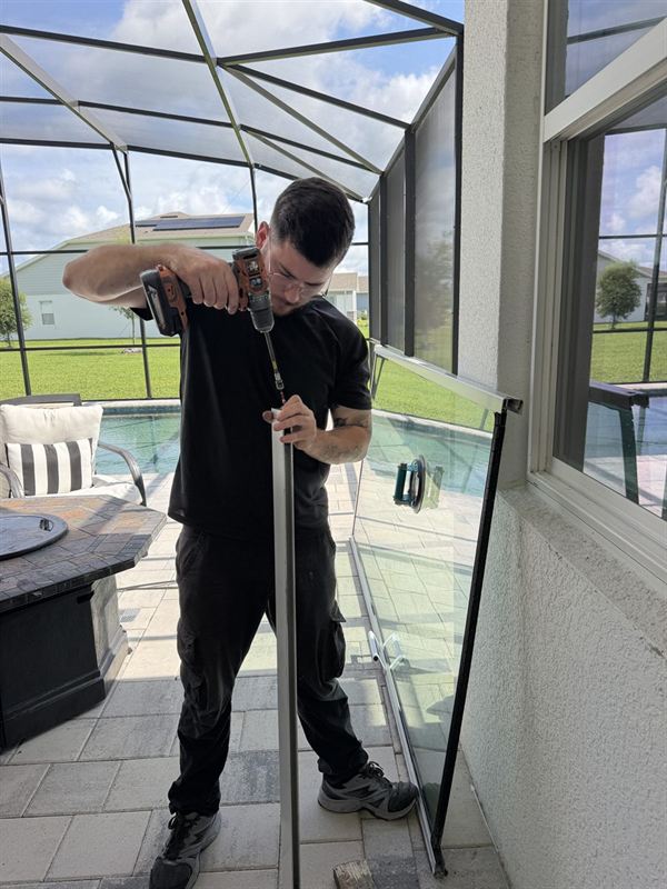 Speedy technician repairing a sliding glass door track on a Florida pool lanai.