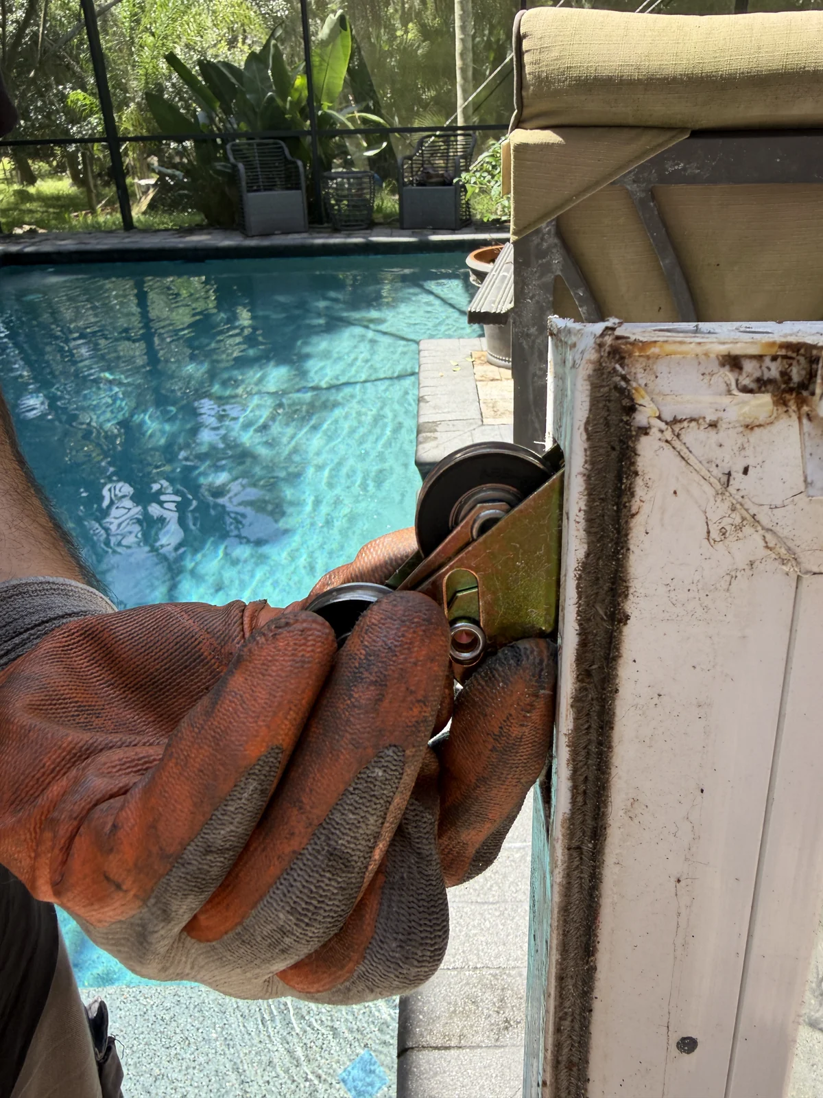 Gloved hands installing a new sealed-bearing sliding door roller, Central Florida