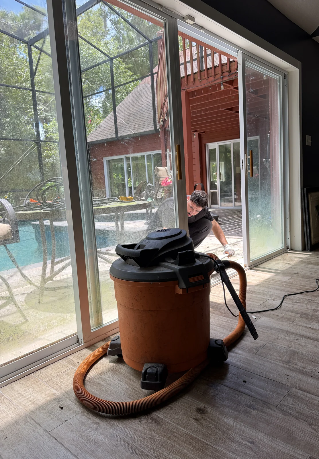 Shop vacuum pulling grit from a sliding door track at a Central Florida home
